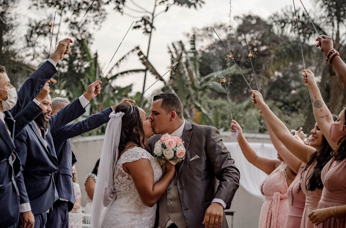 Couple sharing a kiss with sparklers at garden wedding